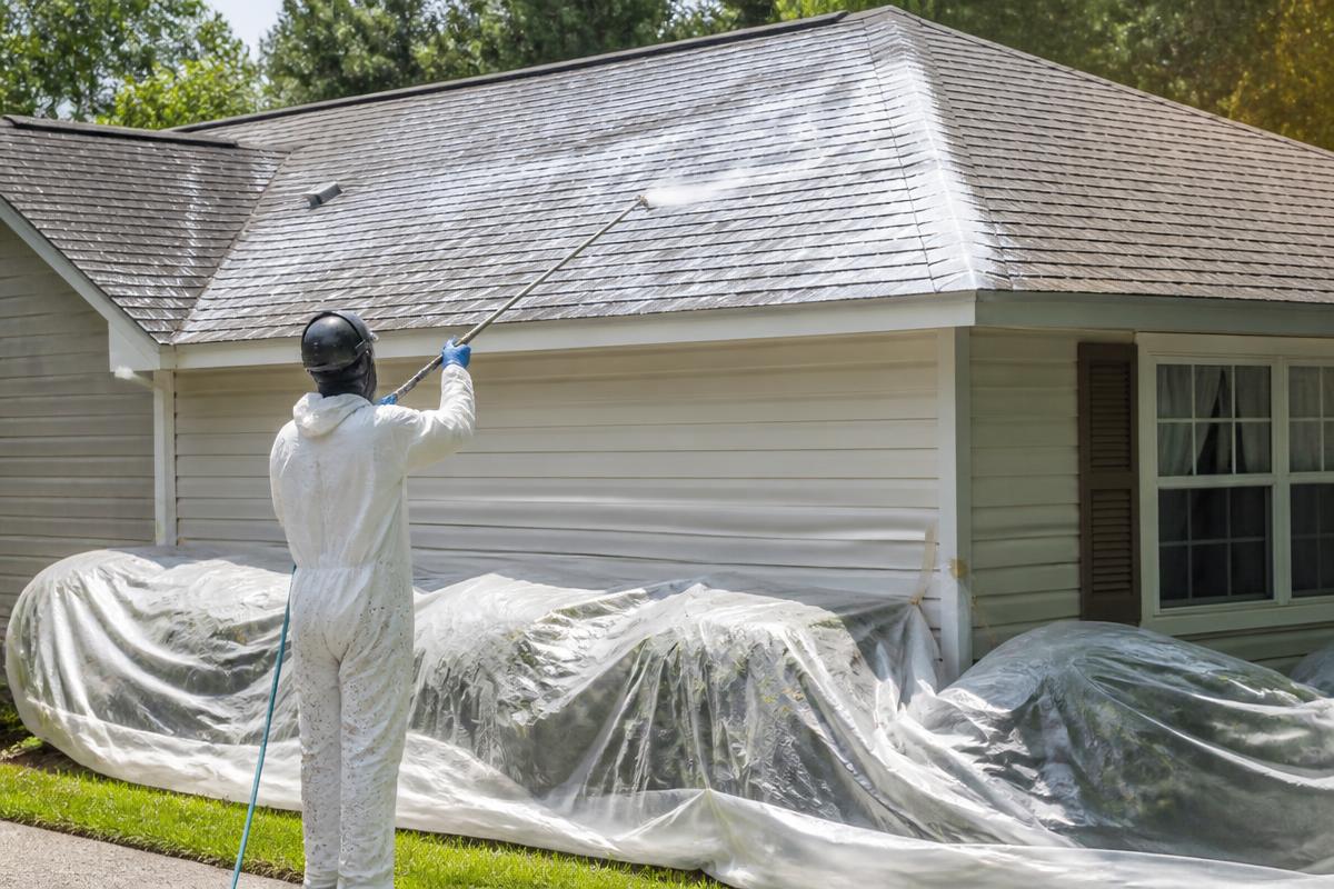Technician applying a low-pressure roof treatment in Sacramento